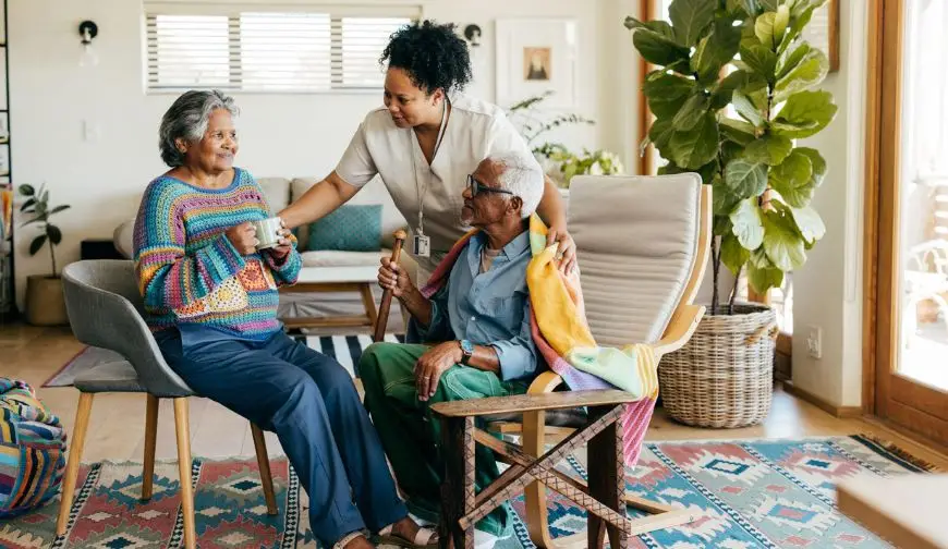 Caregiver enjoying conversation and coffee with a senior woman