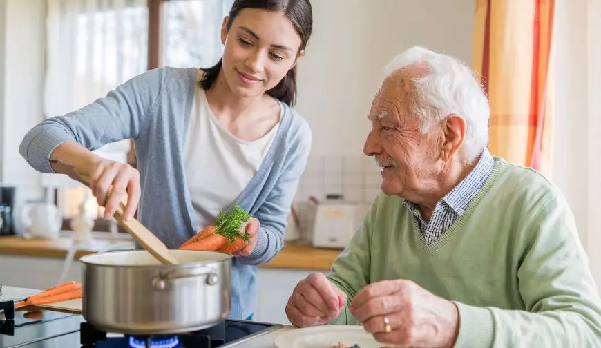 Caregiver preparing a home-cooked meal with a senior