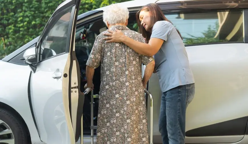 Caregiver helping a senior woman with transportation