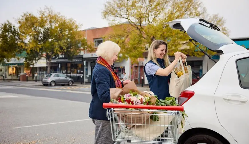 Caregiver helping a senior with grocery shopping and errands